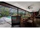 A covered outdoor patio with a dining table and seating overlooking a pool at 17519 Drake Ct, Lutz, FL 33559