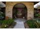 Inviting brick archway, with double doors surrounded by lush landscaping, leads to the home's entrance at 17519 Drake Ct, Lutz, FL 33559