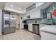 Bright kitchen with stainless steel appliances, white cabinetry, light countertops, and ceramic tile floors at 17519 Drake Ct, Lutz, FL 33559
