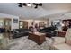 Spacious living room featuring a large leather sectional sofa, ceiling fan, and open floor plan at 17519 Drake Ct, Lutz, FL 33559