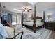 Serene main bedroom with a four-poster bed, skylight, and outdoor access to the pool at 17519 Drake Ct, Lutz, FL 33559