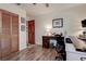 This home office has wood-look floors, a desk, and a louvered closet door at 17519 Drake Ct, Lutz, FL 33559