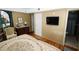 Comfortable bedroom features hardwood floors, dresser, television, and an ensuite bathroom at 1975 W Bay Dr # 301, Largo, FL 33770