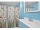 Bright bathroom with stained glass shower door, classic fixtures, and blue walls at 2001 29Th N Ave, St Petersburg, FL 33713