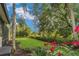 Lush landscaping surrounds the backyard with trimmed hedges and tropical flowers at 20632 Broadwater Dr, Land O Lakes, FL 34638
