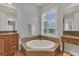 This bathroom features double sinks, a soaking tub, plantation shutters, and tile floors at 20632 Broadwater Dr, Land O Lakes, FL 34638