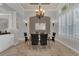Bright dining room with a modern chandelier, decorative wall sconces, and large windows with plantation shutters at 20632 Broadwater Dr, Land O Lakes, FL 34638