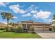 Charming one-story home featuring manicured landscaping, a three-car garage and tropical palm trees at 20632 Broadwater Dr, Land O Lakes, FL 34638