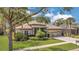Inviting single-story home featuring an attached garage, manicured lawn and tasteful landscaping at 20632 Broadwater Dr, Land O Lakes, FL 34638
