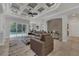 Spacious living room overlooking the pool area, featuring coffered ceilings and a cozy leather sectional at 20632 Broadwater Dr, Land O Lakes, FL 34638