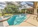 The inviting screened pool features an integrated spa, outdoor kitchen and bar, perfect for entertaining and relaxation at 20632 Broadwater Dr, Land O Lakes, FL 34638
