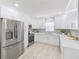 Bright kitchen featuring white cabinets, stainless steel appliances, and light wood flooring at 2220 Calexico S Way, St Petersburg, FL 33712