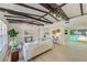Bright living room featuring exposed beams, a large white couch, and seamless access to the pool area at 2220 Calexico S Way, St Petersburg, FL 33712