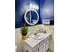 Cozy bathroom with a round mirror, a sink with storage, and modern lighting at 2254 Norwegian Dr # 46, Clearwater, FL 33763