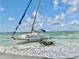 A stranded sailboat resting on the sandy beach creates a striking coastal scene at 2254 Norwegian Dr # 46, Clearwater, FL 33763