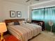 Bright bedroom with a bamboo headboard, fan, rug, green curtains, and leaf prints on the wall at 2254 Norwegian Dr # 46, Clearwater, FL 33763