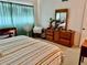 Cozy bedroom with striped bedding, wooden dresser, and sheer curtains at 2254 Norwegian Dr # 46, Clearwater, FL 33763