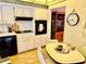 Efficient kitchen featuring white cabinets, black oven, and adjacent dining area at 2254 Norwegian Dr # 46, Clearwater, FL 33763