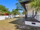 Inviting backyard area with lush greenery, a cozy porch, and a charming black iron railing at 2322 21St S St, St Petersburg, FL 33712