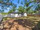 Spacious backyard featuring a white house, a mix of white and wood fences, and mature trees providing ample shade at 2322 21St S St, St Petersburg, FL 33712