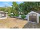 Landscaped backyard with shed and partial view of screened-in patio, great for outdoor living at 2410 E Bougainvillea Ave, Tampa, FL 33612