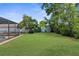 Expansive backyard with healthy green grass, foliage and tall privacy fence; perfect for activities and entertaining at 2444 Magellan Ave, Spring Hill, FL 34608