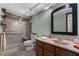 Bathroom featuring glass shower with grab bars, neutral countertops and decorative framed mirror at 2444 Magellan Ave, Spring Hill, FL 34608