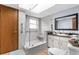 Updated bathroom with glass shower, hand rails, modern fixtures, and ample natural light from window at 2444 Magellan Ave, Spring Hill, FL 34608