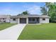 Charming single-story home featuring a well-manicured lawn and a screened-in front porch at 2444 Magellan Ave, Spring Hill, FL 34608
