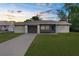 Charming single-story home with an attached garage and a spacious front yard at sunset at 2444 Magellan Ave, Spring Hill, FL 34608