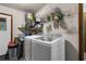Functional laundry room featuring modern washer and dryer, ample shelving, and convenient access to the outside at 2444 Magellan Ave, Spring Hill, FL 34608