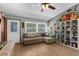 Comfortable living room with a sectional sofa, bright windows, ceiling fan, and built-in shelving unit at 2444 Magellan Ave, Spring Hill, FL 34608