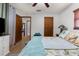 Comfortable main bedroom with wood-look floors, ceiling fan, and easy access to the ensuite bathroom at 2444 Magellan Ave, Spring Hill, FL 34608