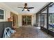 View of the enclosed patio with brick flooring, paneled entry doors and ceiling fan at 2444 Magellan Ave, Spring Hill, FL 34608