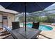 Relaxing poolside area with ample seating, perfect for entertaining under a large umbrella at 2444 Magellan Ave, Spring Hill, FL 34608
