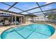 Backyard pool and patio area with a screened enclosure, perfect for outdoor entertaining and relaxation at 2444 Magellan Ave, Spring Hill, FL 34608