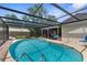 Outdoor pool with screened enclosure and ample seating for relaxing by the poolside at 2444 Magellan Ave, Spring Hill, FL 34608