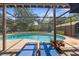 Inviting backyard oasis featuring a sparkling pool, covered patio, and comfortable lounge chairs at 2444 Magellan Ave, Spring Hill, FL 34608