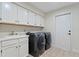 Functional laundry room with modern washer/dryer and ample cabinet storage at 2513 Buckhorn Run Dr, Valrico, FL 33596