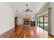 The living room features hardwood flooring, a brick fireplace, and large windows with a view of the pool at 2513 Buckhorn Run Dr, Valrico, FL 33596