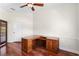 A home office features a wood desk, hardwood floors, ceiling fan, and trim work at 2513 Buckhorn Run Dr, Valrico, FL 33596