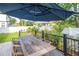 Backyard deck with a wooden table and umbrella, framed by lush greenery and a manicured lawn, creating an inviting outdoor space at 2707 W Fig St, Tampa, FL 33609