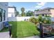 Well-kept backyard with artificial turf, recreational amenities, and tropical landscaping, enclosed by a pristine white fence at 2707 W Fig St, Tampa, FL 33609