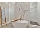 This bathroom features an elegant soaking tub with modern fixtures and a stylish marble tiled wall at 2707 W Fig St, Tampa, FL 33609
