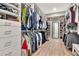 This walk-in closet features wood floors and a vast selection of clothing on display with recessed lighting at 2707 W Fig St, Tampa, FL 33609
