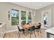 Bright dining area with a natural wood table, six chairs, backyard views and stylish pendant lighting at 2707 W Fig St, Tampa, FL 33609