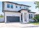 Well-maintained two-story home with a modern design, dark trim, and manicured lawn at 2707 W Fig St, Tampa, FL 33609