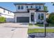Charming two-story home with a modern design, featuring a black garage door at 2707 W Fig St, Tampa, FL 33609