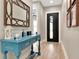 Elegant foyer featuring a blue console table, wood floors, and a stylish mirror at 2707 W Fig St, Tampa, FL 33609