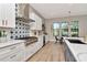 Bright kitchen boasts stainless steel appliances, a blue and white backsplash, plus an island with white countertop at 2707 W Fig St, Tampa, FL 33609